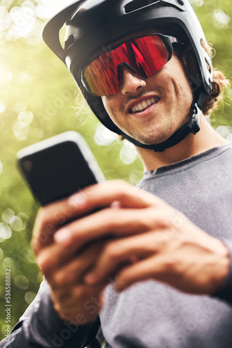 Adventure, sports man with smartphone in forest check GPS location, fitness goal or progress on mobile app. Athletic in nature reading online results, web for triathlon tips on 5g network mobile app © Clement C/peopleimages.com