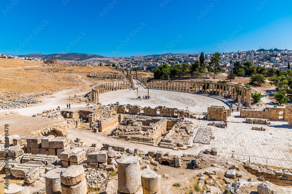 An aerial view across the Oval Plaza and colonnaded street in the ancient Roman settlement of Gerasa in Jerash, Jordan in summertime