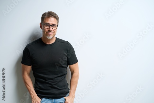Portrait of happy casual older man smiling, Mid adult, mature age guy at white wall, Isolated on white background, copy space.