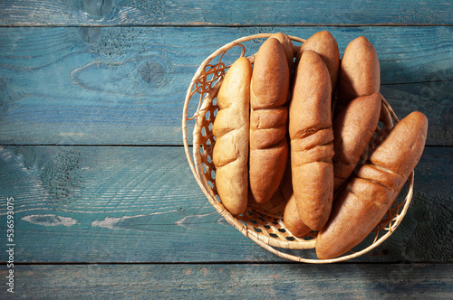 Mini baguettes in a basket on a wooden table. Country style