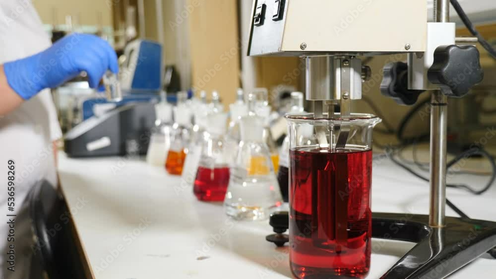 Formalin production testing. liquids being mixed in transparent bowl. Pharmacology specialist at work. Quality control in laboratory at chemical factory. Liiquid in flask under laboratory conditions Formalin production testing. liquids being mixed in transparent bowl. Pharmacology specialist at work. Quality control in laboratory at chemical factory. Liiquid in flask under laboratory conditions