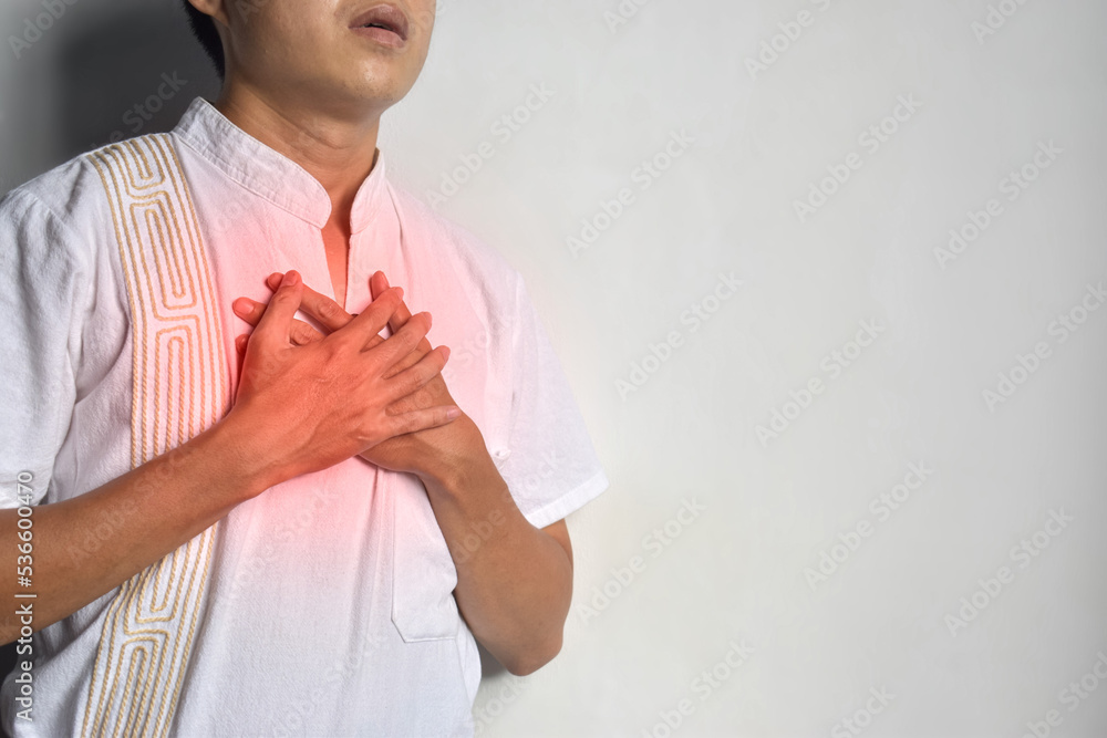 Asian man suffering from tightness of chest. It can be caused by asthma, bronchitis, bronchiolitis, pneumonia, myocardial infarction, ischemic heart disease, esophagitis, etc. Asian man suffering from tightness of chest. It can be caused by asthma, bronchitis, bronchiolitis, pneumonia, myocardial infarction, ischemic heart disease, esophagitis, etc.