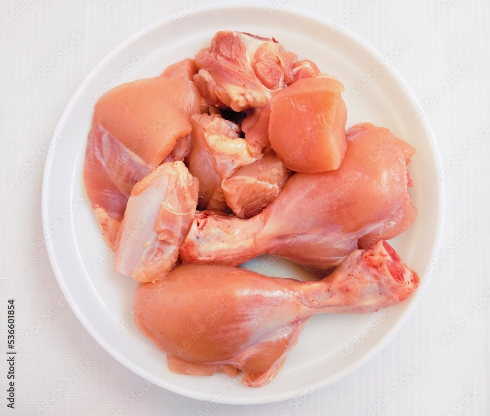 Raw fresh chicken meat white-meat murghi ka gosht boti raw-frango raw-poulet, food uncooked poultry-meat raw-pollo hen-meat cut pieces on a plate fillets and drumstick bird-meat closeup image photo 