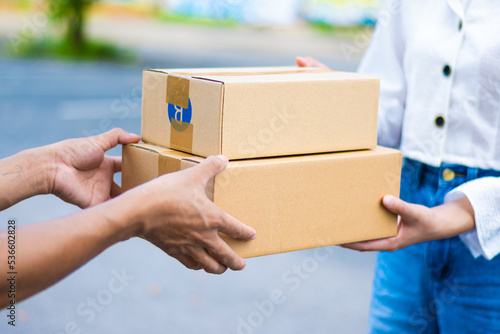 female hand receiving parcel from male employee.