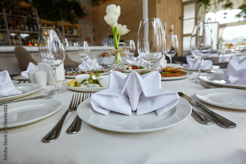 A napkin in a plate. Decoration for the table before the reception. The art of folding napkins into beautiful shapes.