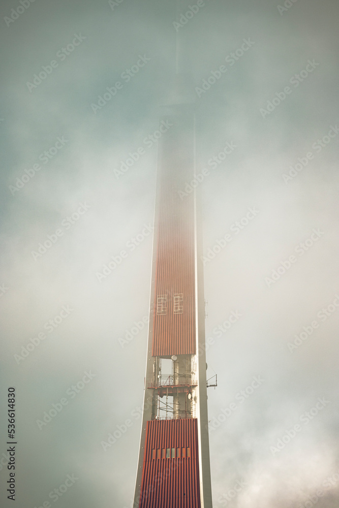 The TV tower in Riga, Latvia in the morning embraced in thick fog and clouds