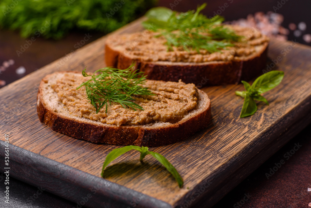 Homemade meat snack liver pate with toast on a dark concrete background Homemade meat snack liver pate with toast on a dark concrete background