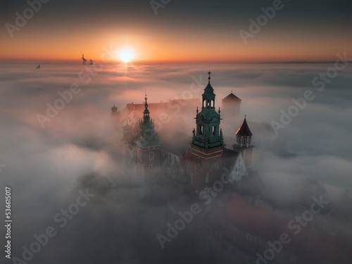 Wawel Castle in Kraków, Poland. Aerial, drone photo of the Royal Castle above the morning fog during the sunrise. © Adam