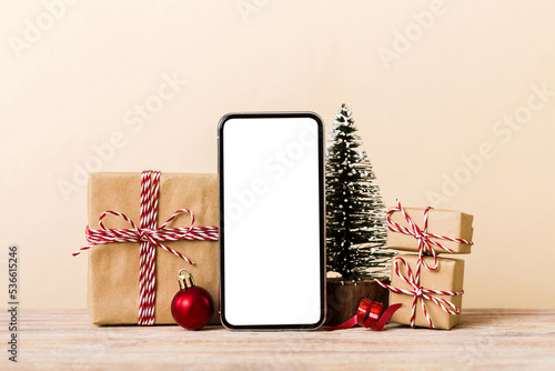 Digital phone mock up with rustic Christmas decorations for app presentation with empty space for you design. Christmas online shopping concept. Tablet with copy space on colored background photo