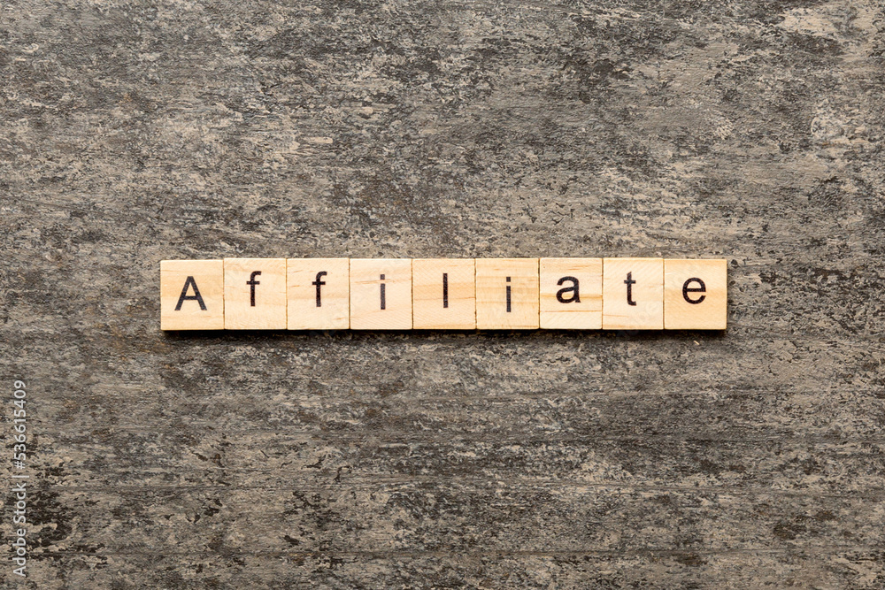 AFFILIATE word written on wood block. AFFILIATE text on cement table for your desing, concept AFFILIATE word written on wood block. AFFILIATE text on cement table for your desing, concept