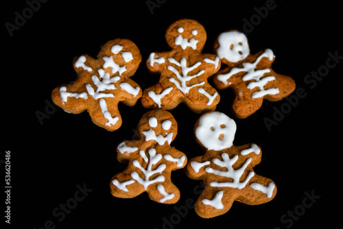 A group of baked gingerbread men on black background. Halloween Gingerbread Cookies on black background, selective focus, and blank space. creative Halloween background. Top view © Юлія Костюченко