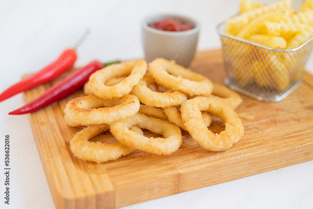 fast food breaded onion rings fried with sauce on a wooden board fast food breaded onion rings fried with sauce on a wooden board