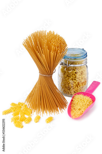 Pasta of different types photographed against a white background. Spaghetti tied with a rope. Macaroni in a jar. Vermicelli in a plastic spatula