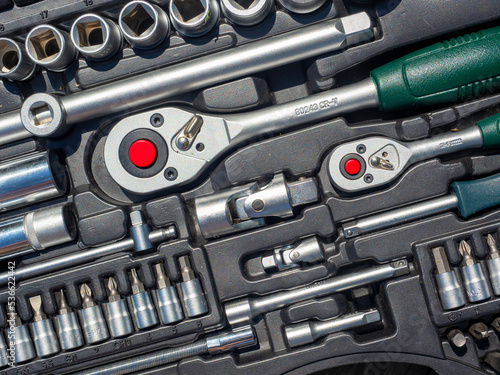 A close-up of a set of tools for repairing a car and other things. wrenches, bits, attachments. Top view, flat lay