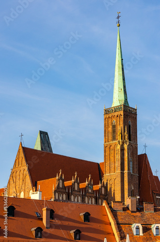 Holy Cross collegiate gothic cathedral rising over Ostrow Tumski Island and Odra river in historic old town quarter of Wroclaw in Poland photo