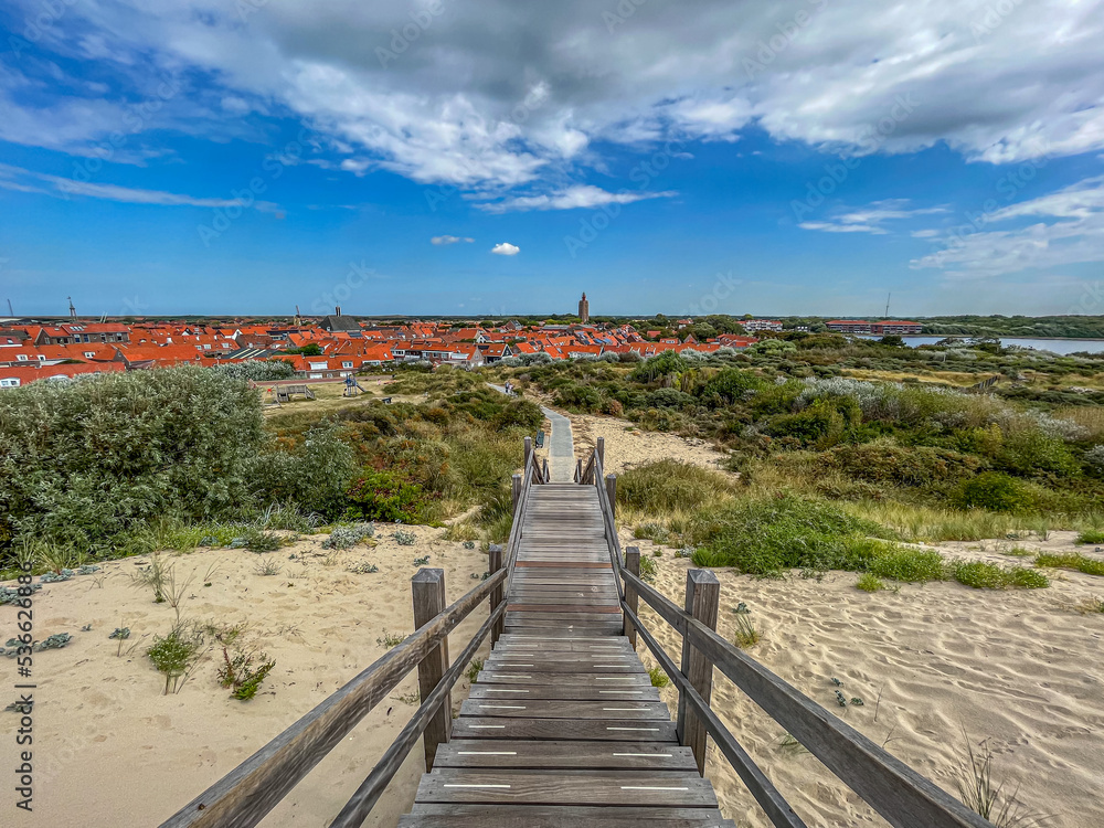 Wooden staircase leading away from the beach with a view of the Westkapelle lighthouse