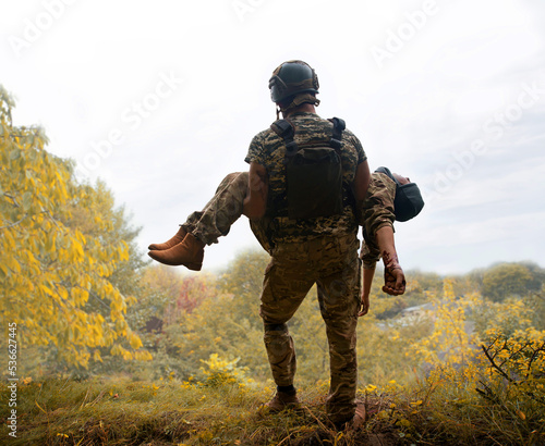 Foto The commander carries a wounded soldier