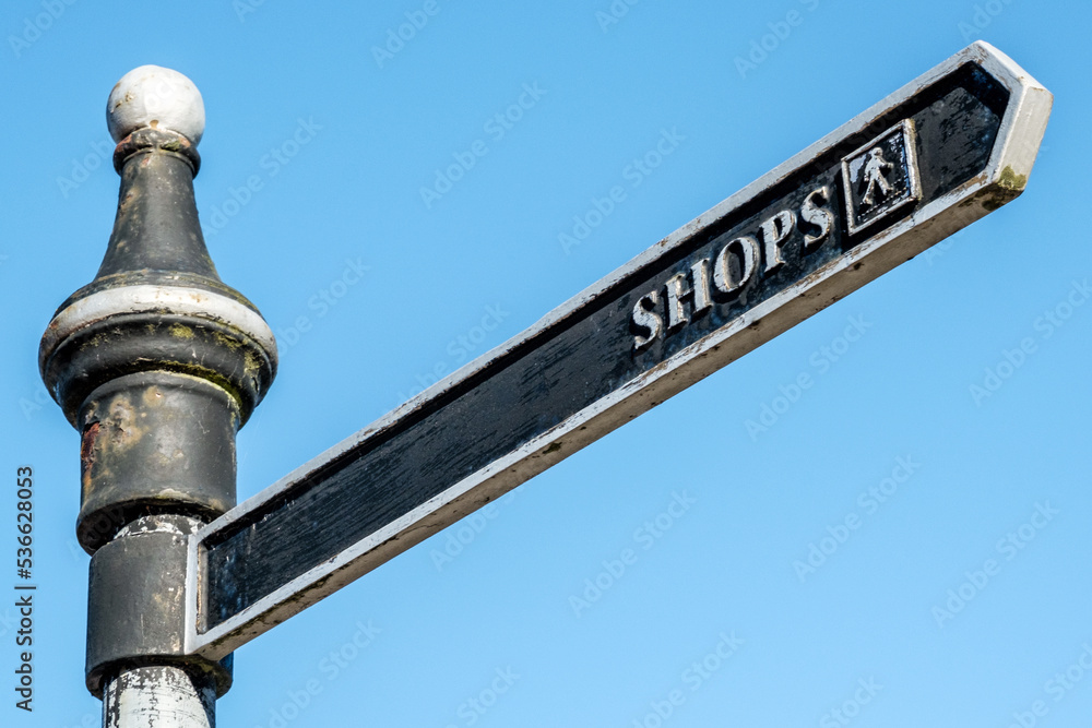 Fototapeta premium Public Street Sign Pointing Way To Shops With No People