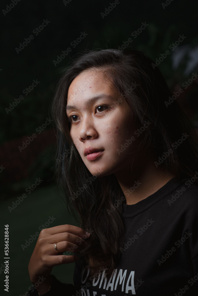 Asian young woman who wants to express something with expression. Asian female model wearing black t-shirt on bokeh background. Asian young woman who wants to express something with expression. Asian female model wearing black t-shirt on bokeh background.