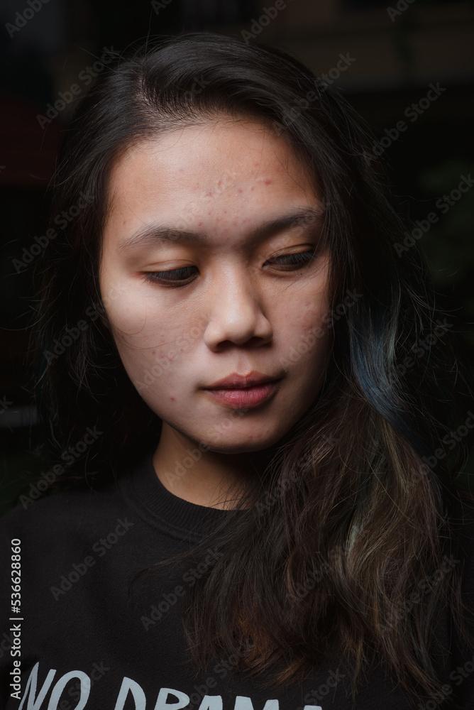 Asian young woman who wants to express something with expression. Asian female model wearing black t-shirt on bokeh background.