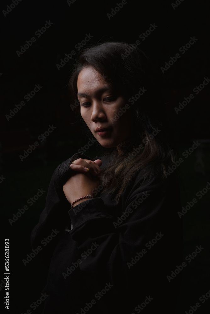 Asian young woman who wants to express something with expression. Asian female model wearing black t-shirt on bokeh background. Asian young woman who wants to express something with expression. Asian female model wearing black t-shirt on bokeh background.