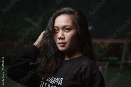 Asian young woman who wants to express something with expression. Asian female model wearing black t-shirt on bokeh background.