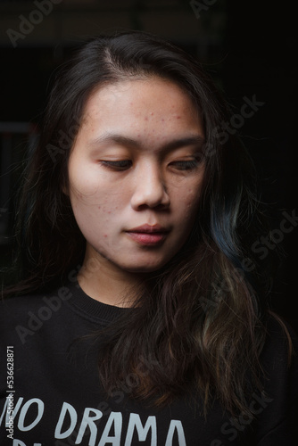 Asian young woman who wants to express something with expression. Asian female model wearing black t-shirt on bokeh background.