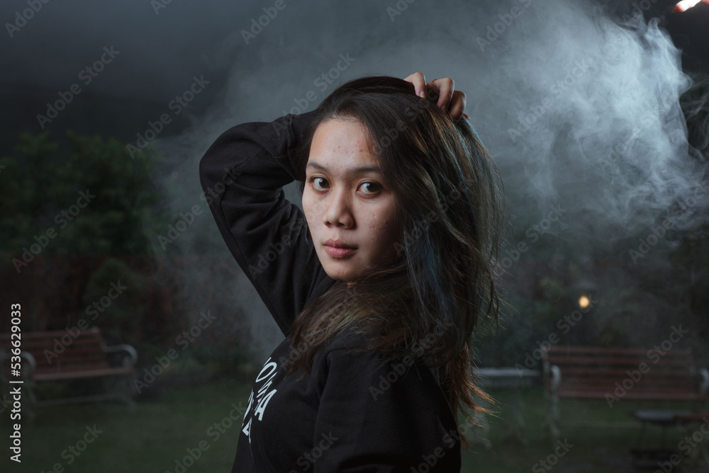 Asian young woman who wants to express something with expression. Asian female model wearing black t-shirt on bokeh background. Asian young woman who wants to express something with expression. Asian female model wearing black t-shirt on bokeh background.