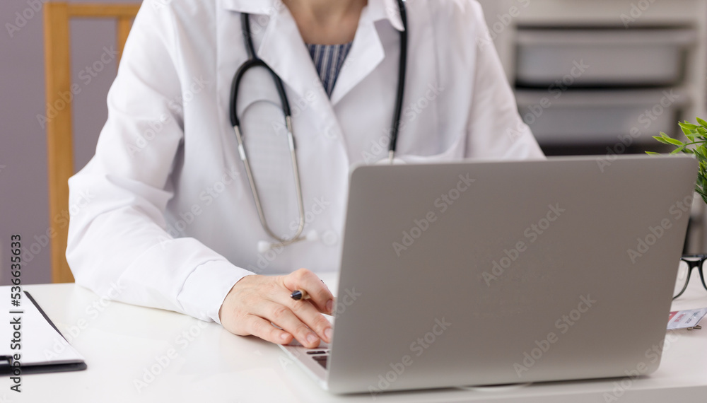 The doctor works in his office, sees patients and takes notes. The doctor works at the computer in the hospital. Medical photo with copy space. High quality photo The doctor works in his office, sees patients and takes notes. The doctor works at the computer in the hospital. Medical photo with copy space. High quality photo