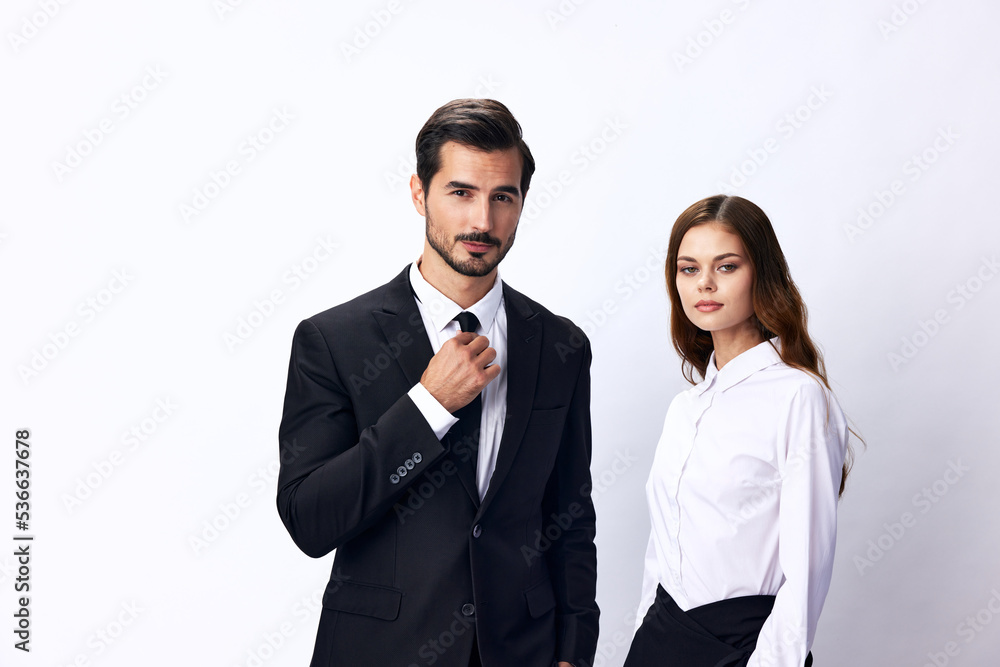 A man and a business woman in business attire look at the camera against a white, isolated background. Stylish business concept paired between employees startup copy space A man and a business woman in business attire look at the camera against a white, isolated background. Stylish business concept paired between employees startup copy space