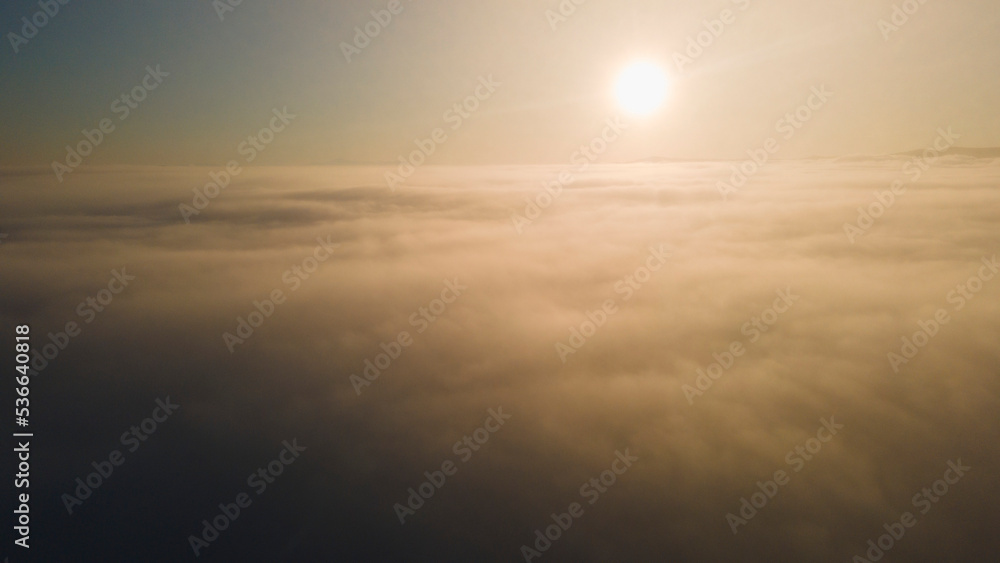 Sun, Sunrise and Horizon over a clouds, aerial