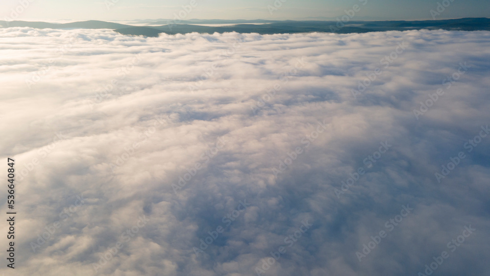 Early Sunrise and Horizon over the clouds cover mountains ridge, aerial Early Sunrise and Horizon over the clouds cover mountains ridge, aerial