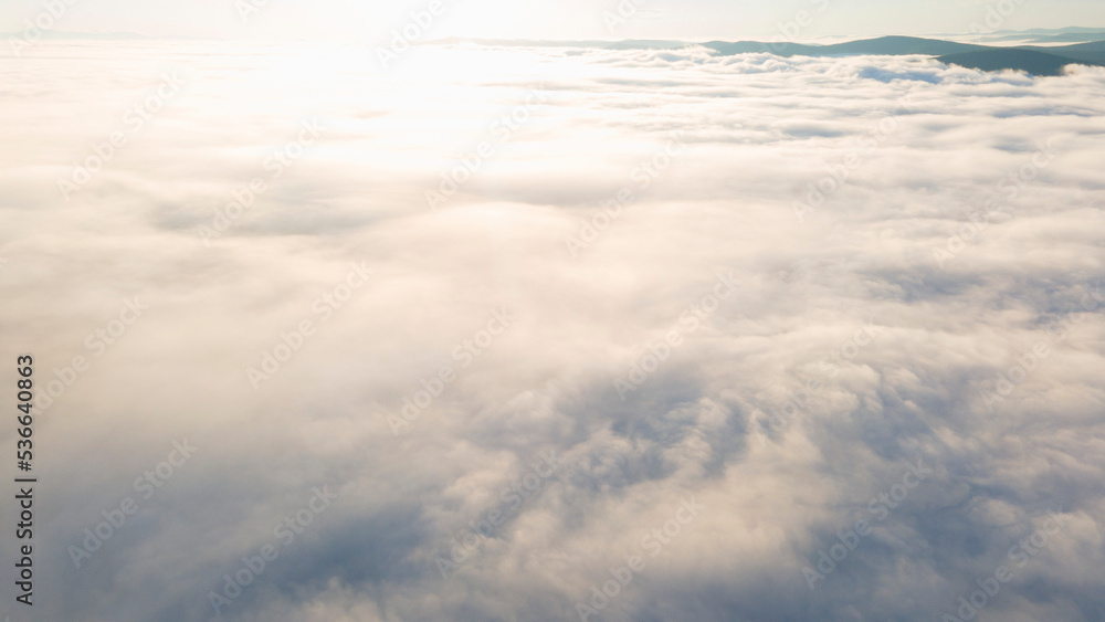 Early Sunrise and Horizon over the clouds cover mountains ridge, aerial view