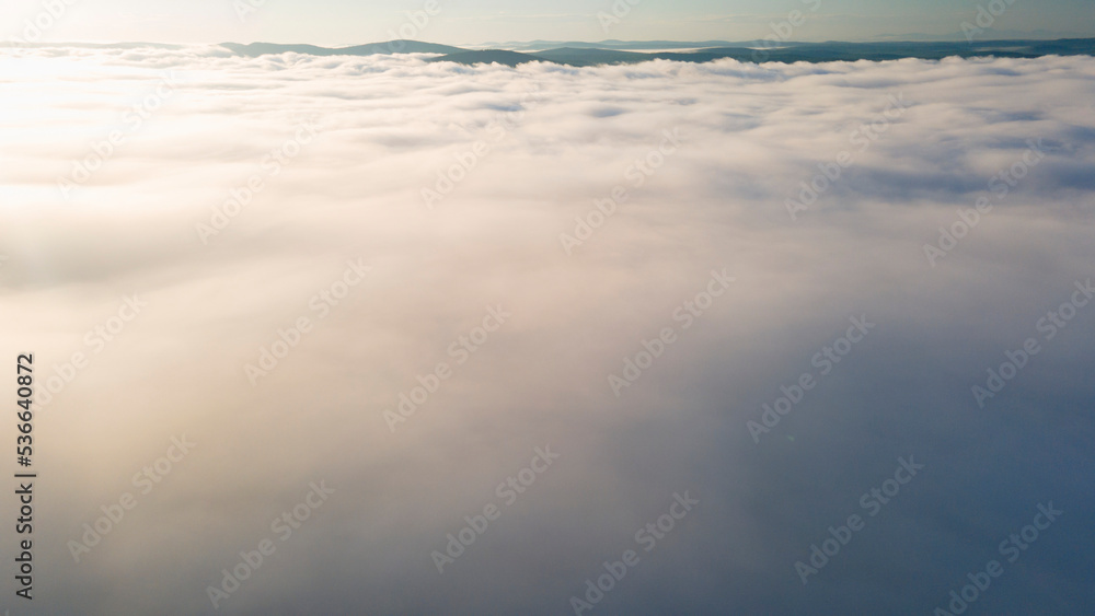Early Sunrise and Horizon over the clouds cover mountains ridge, drone view Early Sunrise and Horizon over the clouds cover mountains ridge, drone view