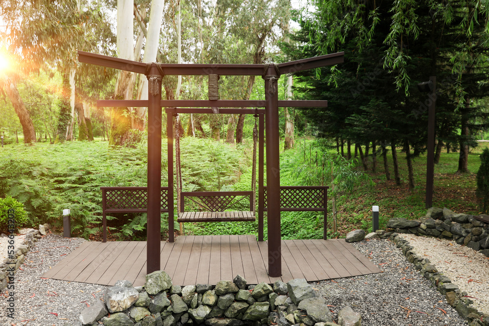 Beautiful brown metal swing in tranquil park Beautiful brown metal swing in tranquil park