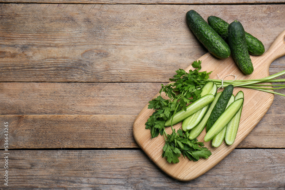 Fresh ripe cucumbers and parsley on wooden table, flat lay. Space for text Fresh ripe cucumbers and parsley on wooden table, flat lay. Space for text