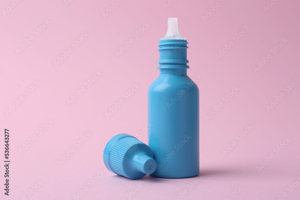 Bottle of medical drops on pink background Bottle of medical drops on pink background