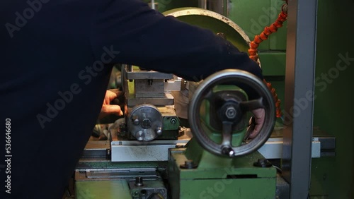 worker cutting a metal with lathe machine