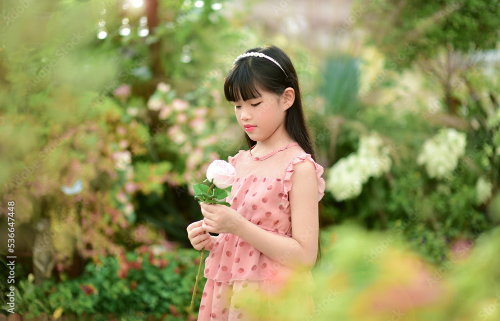 Romantic beauty girl holding rose in garden Romantic beauty girl holding rose in garden