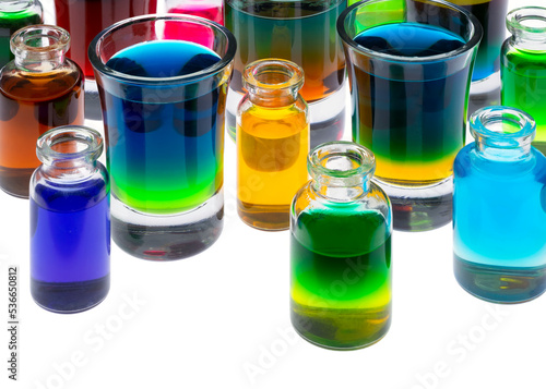 Colored water in small glass containers on white background