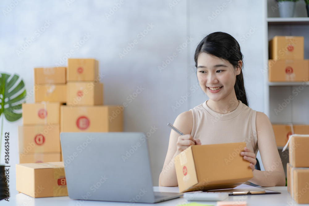 sme business idea cute asian woman selling online at home with laptop to take orders and to deliver yellow parcel boxes online delivery ideas sme business idea cute asian woman selling online at home with laptop to take orders and to deliver yellow parcel boxes online delivery ideas