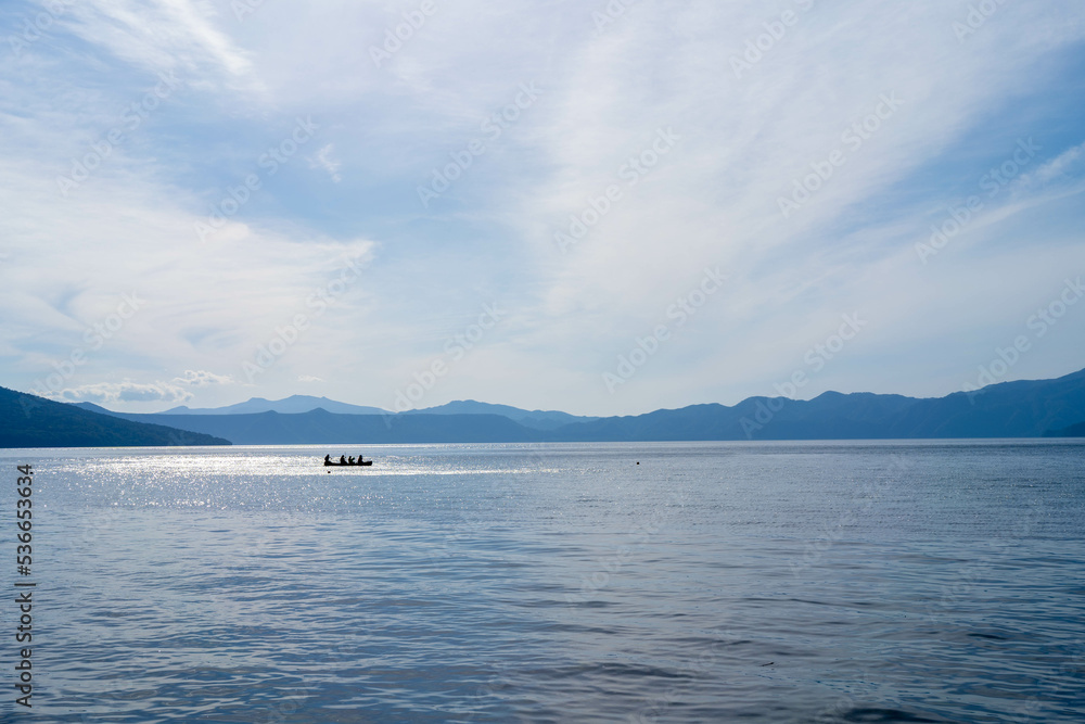 北海道 支笏湖の湖と青い空・湖面に浮かぶカヌー