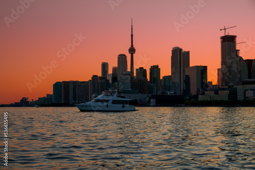 Toronto downtown cityscape with skyscrapers  white yacht and amazing color sunset sky