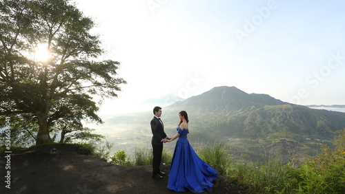 the groom and bride are on top of mountain walking and dancing under the sunlight