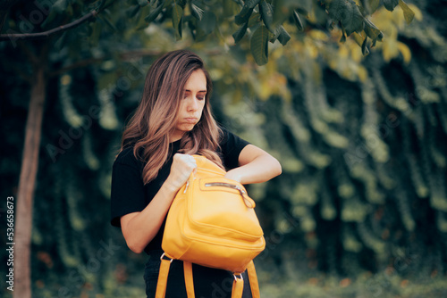 Woman Looking into her Messy Bag Not Finding the Keys. Careless girl misplacing her stuff in her cluttered backpack 
 photo