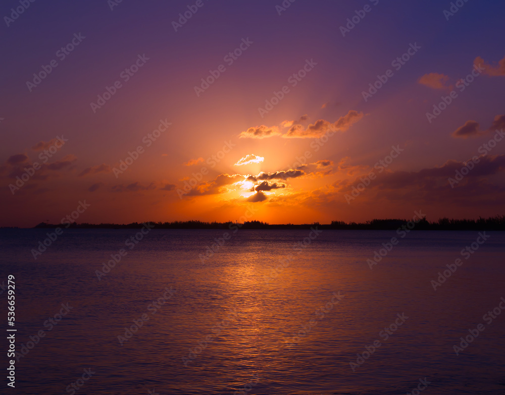 Beautiful over the sea golden blue orange tropical sunset reflected in sea