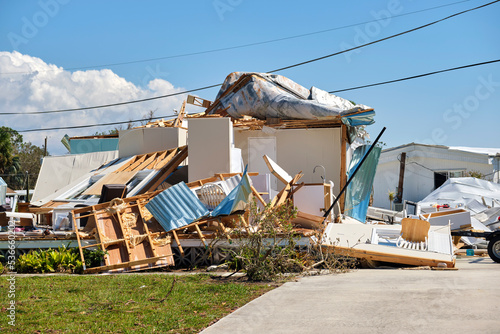 Severely damaged house after hurricane Ian in Florida mobile home residential area. Consequences of natural disaster photo