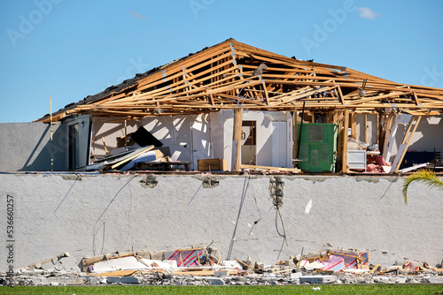 Severely damaged house after hurricane Ian in Florida mobile home residential area. Consequences of natural disaster photo