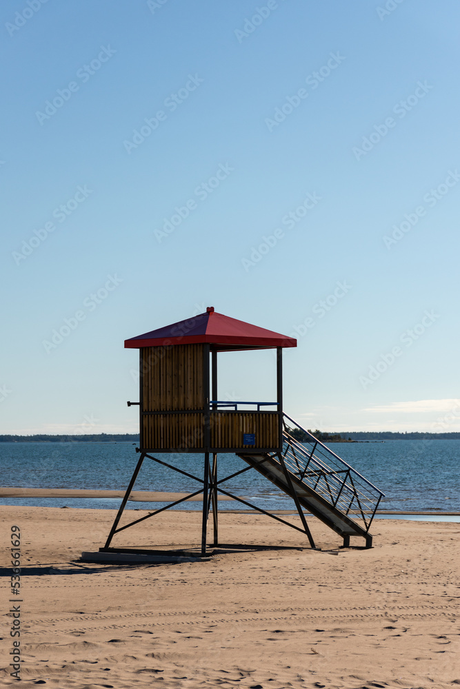 Wooden lifeguard tower with a red roof on the sandy beach of Yyteri in Pori, Finland with clear blue sky in the background