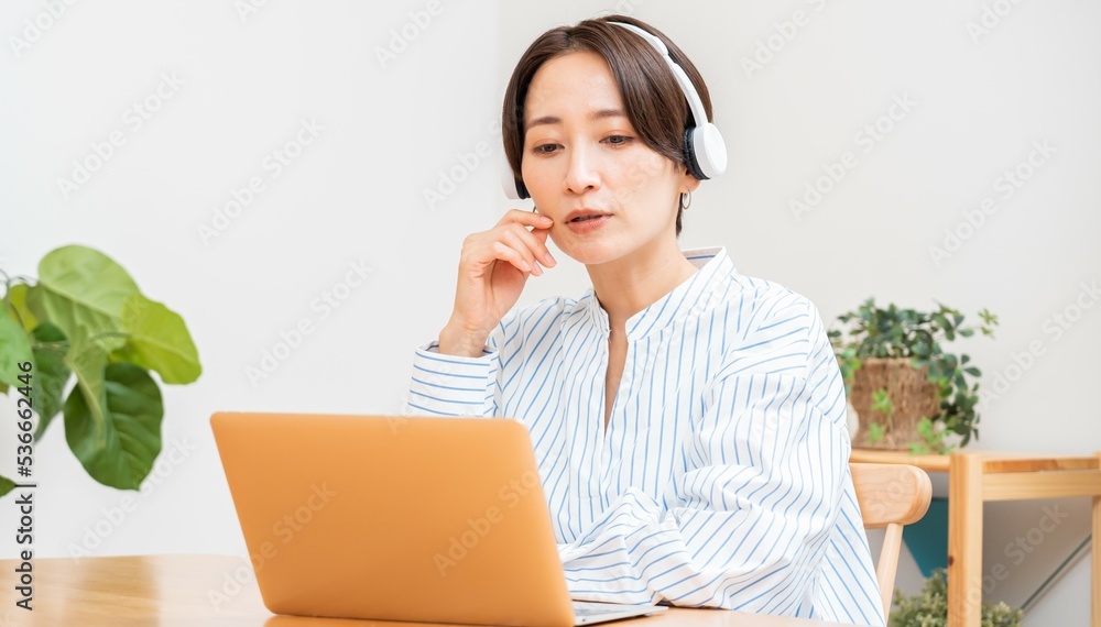 パソコンに向かって話すヘッドホンをつけた日本人女性